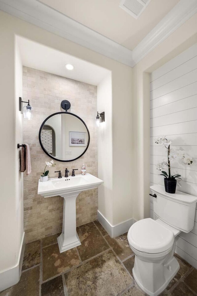 bathroom featuring toilet and crown molding