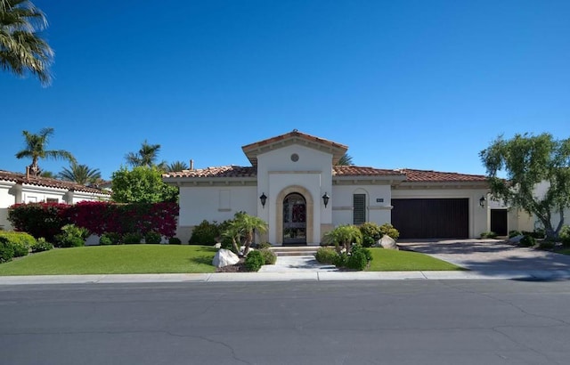 mediterranean / spanish-style home with a front lawn and a garage