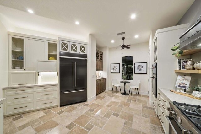 kitchen featuring ceiling fan, cream cabinetry, and high quality appliances