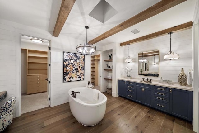 bathroom with wood walls, hardwood / wood-style flooring, a washtub, vanity, and beamed ceiling