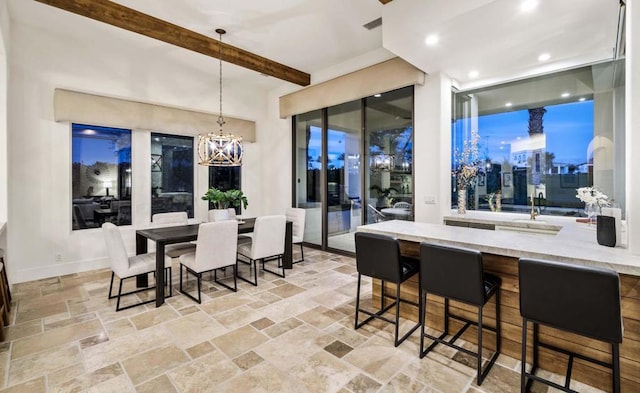 dining area with an inviting chandelier and beam ceiling