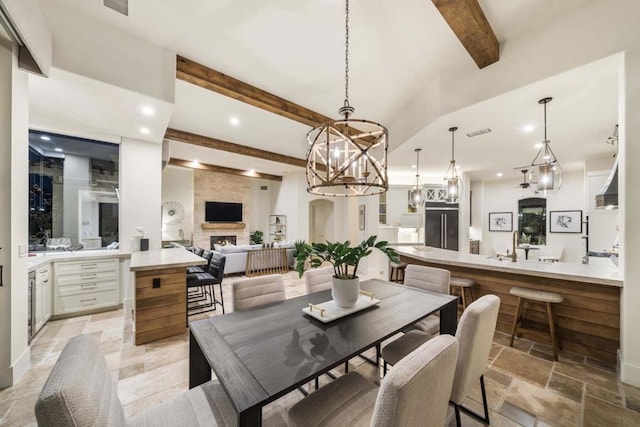 dining room featuring beamed ceiling and a fireplace