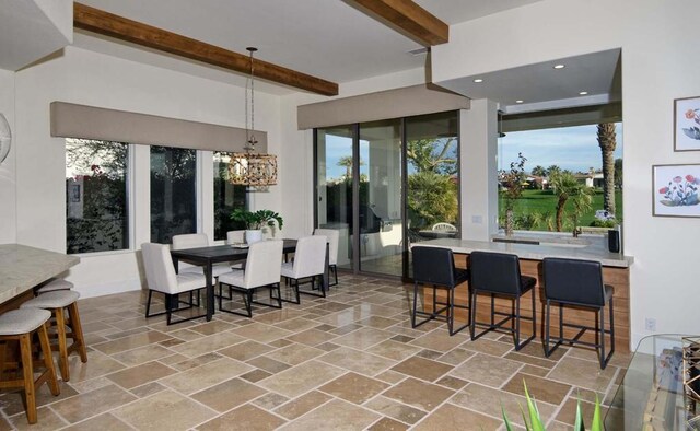 dining room featuring beam ceiling and a chandelier