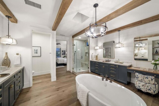 full bathroom with wood-type flooring, vanity, toilet, beam ceiling, and independent shower and bath