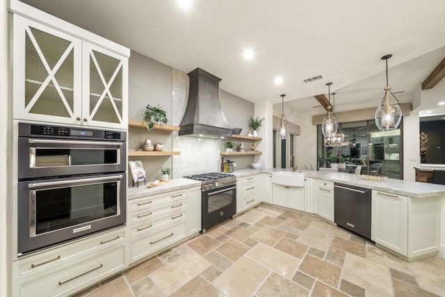 kitchen featuring kitchen peninsula, appliances with stainless steel finishes, hanging light fixtures, custom range hood, and sink