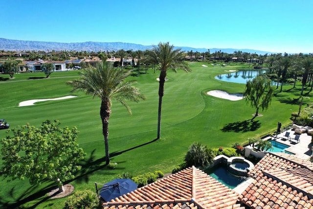 view of property's community featuring a water and mountain view and a lawn