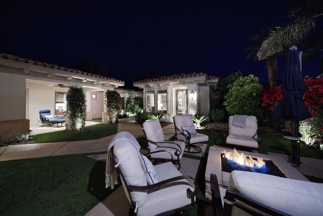 patio at twilight featuring an outdoor fire pit