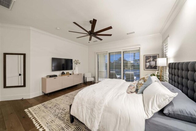 bedroom with dark wood-type flooring, ceiling fan, and ornamental molding