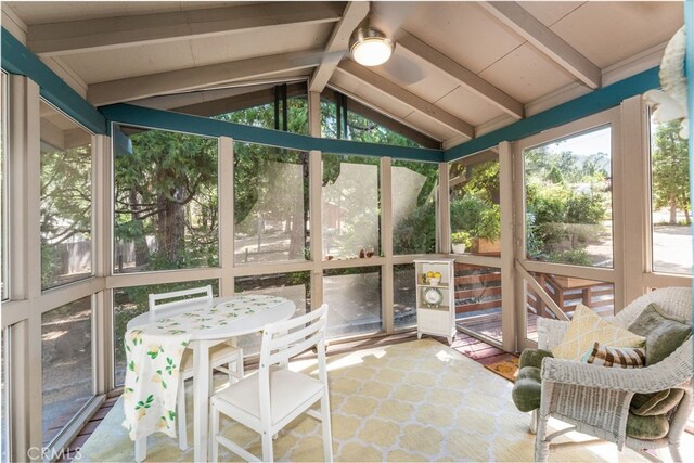 sunroom featuring ceiling fan and lofted ceiling with beams