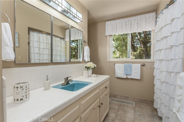 bathroom with tasteful backsplash and vanity