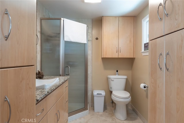 bathroom with a shower with shower door, toilet, vanity, and tile patterned flooring