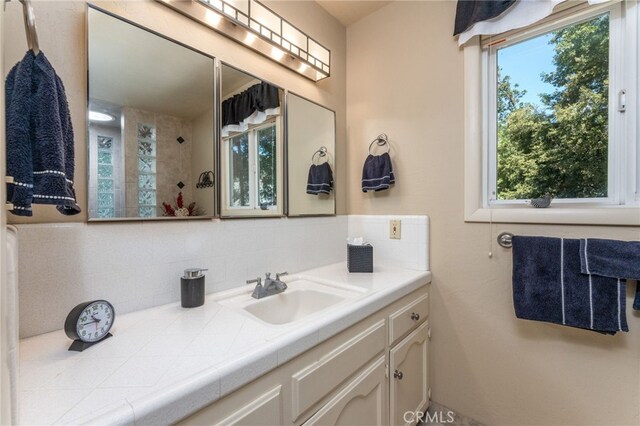 bathroom with tasteful backsplash and vanity