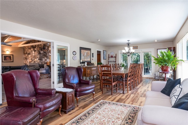 living room featuring wood-type flooring, french doors, and a notable chandelier