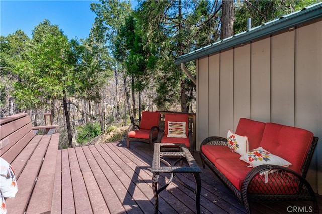 wooden terrace with an outdoor living space