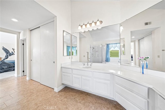 bathroom with an enclosed shower, vanity, and lofted ceiling