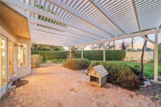 patio terrace at dusk featuring a pergola