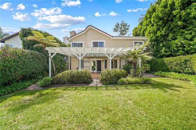 back of house featuring a lawn and a pergola