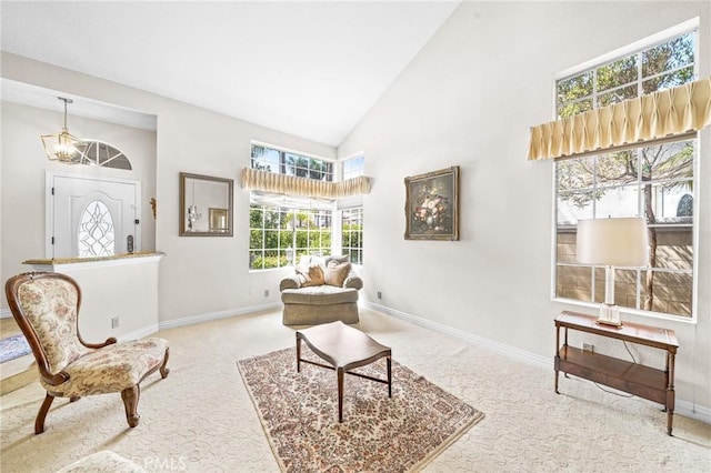 sitting room with carpet floors and high vaulted ceiling