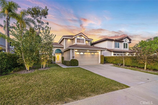 view of front of property featuring a garage and a lawn