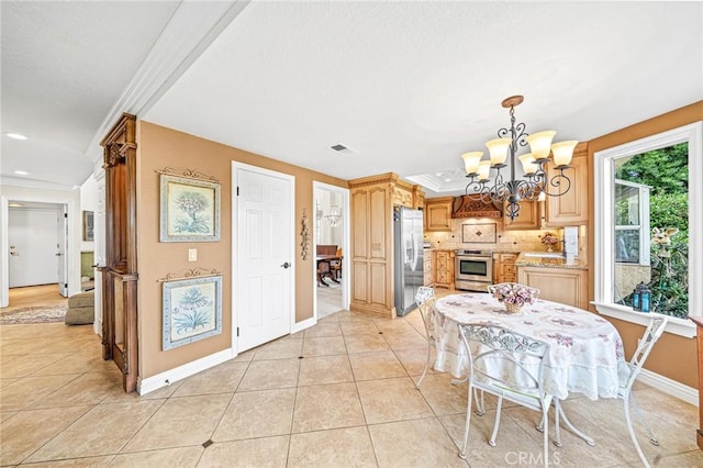 tiled dining area featuring a notable chandelier and ornamental molding