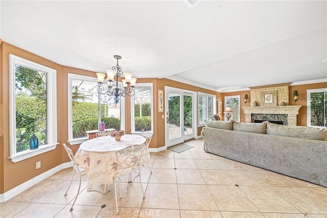 sunroom / solarium featuring a wealth of natural light, a fireplace, and a notable chandelier