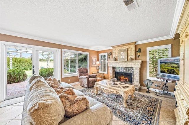 living room featuring light tile patterned flooring, a textured ceiling, crown molding, and a fireplace