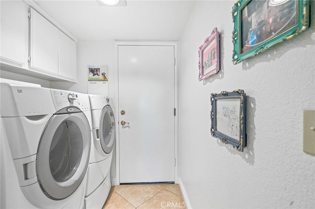 laundry room featuring washing machine and dryer, light tile patterned flooring, and cabinets