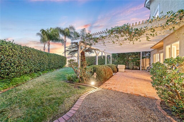 yard at dusk featuring a pergola