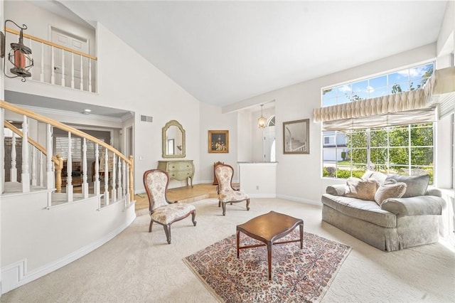 carpeted living room with high vaulted ceiling