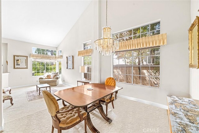 carpeted dining area featuring high vaulted ceiling and a notable chandelier