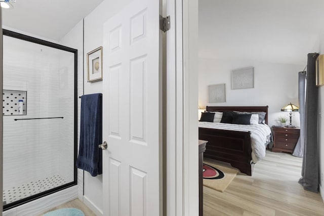 bathroom featuring hardwood / wood-style flooring and a shower with door