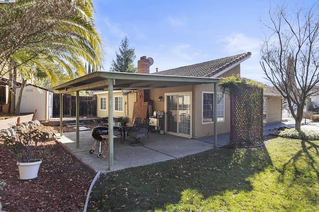 rear view of house with a patio area, a shed, and a lawn