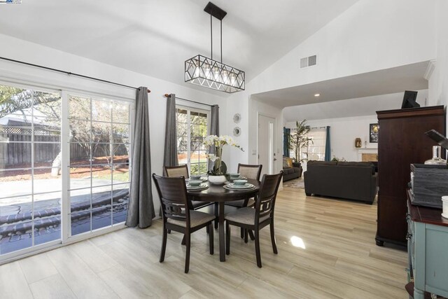 dining room featuring lofted ceiling, an inviting chandelier, and light hardwood / wood-style floors