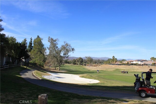 surrounding community with a mountain view and a yard