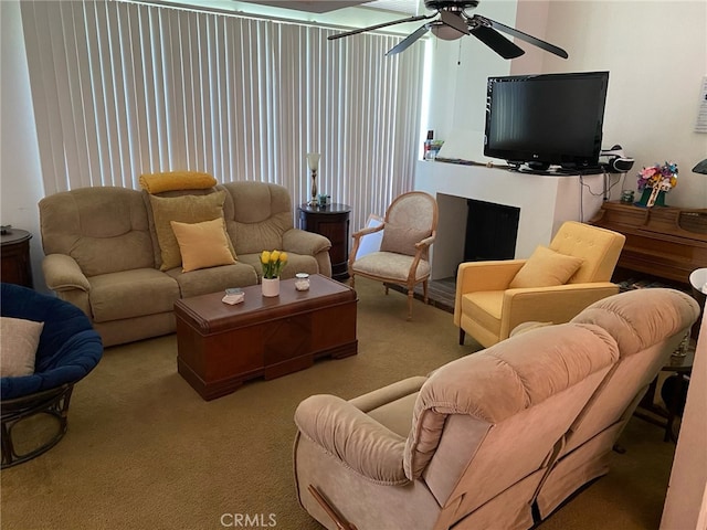 carpeted living room featuring a fireplace and ceiling fan