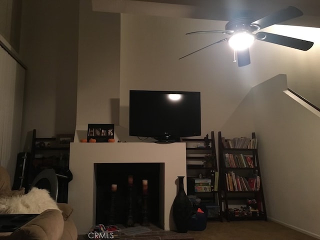 living room featuring ceiling fan and a fireplace