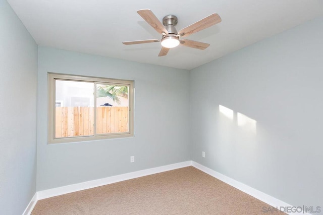 carpeted spare room with ceiling fan