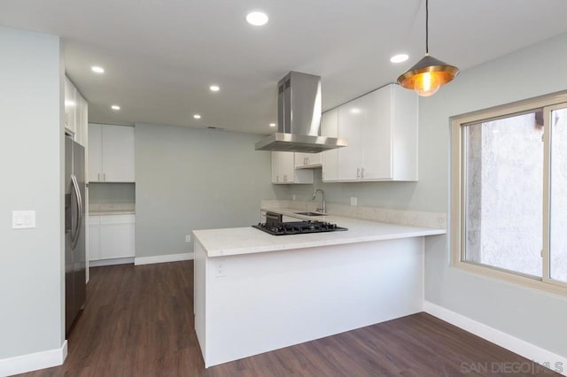 kitchen featuring white cabinets, ventilation hood, kitchen peninsula, and pendant lighting