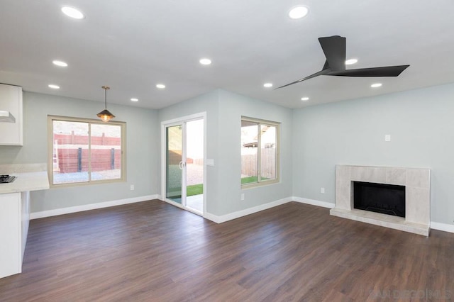 unfurnished living room with ceiling fan, dark hardwood / wood-style floors, and a fireplace