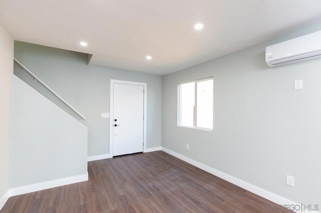 interior space featuring dark wood-type flooring and an AC wall unit