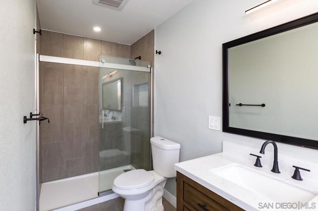 bathroom with toilet, a shower with door, and vanity