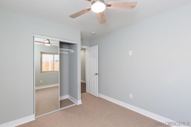 unfurnished bedroom featuring a closet, light colored carpet, and ceiling fan