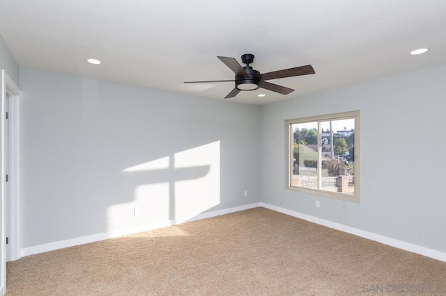 carpeted spare room with ceiling fan