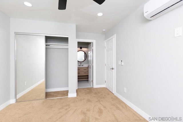 unfurnished bedroom featuring a wall unit AC, ceiling fan, a closet, and light colored carpet