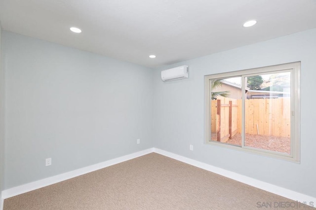 spare room featuring carpet floors and an AC wall unit