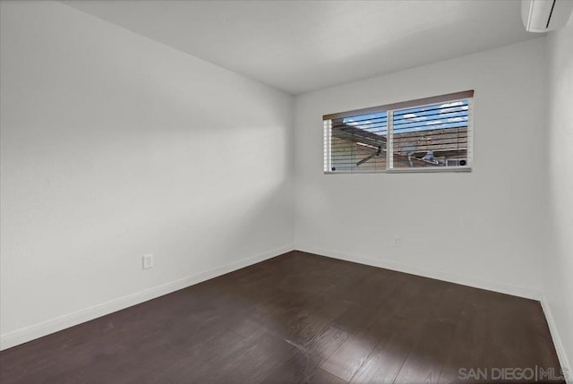 spare room featuring dark hardwood / wood-style floors and a wall mounted AC