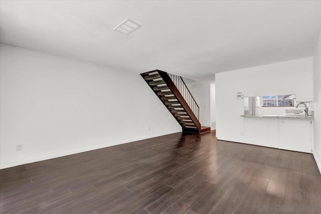 unfurnished living room featuring dark hardwood / wood-style flooring and sink