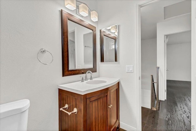 bathroom featuring toilet, vanity, and hardwood / wood-style flooring