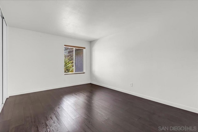 unfurnished room featuring dark wood-type flooring