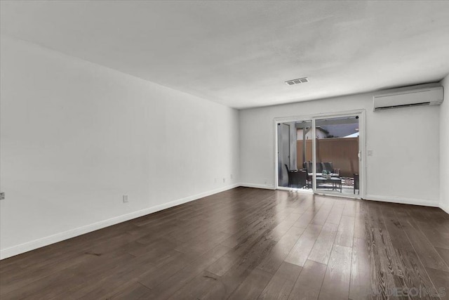 empty room with dark hardwood / wood-style floors and an AC wall unit